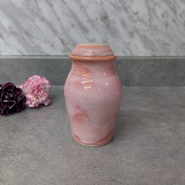 Reliquary in the shape of a small pink elongated urn